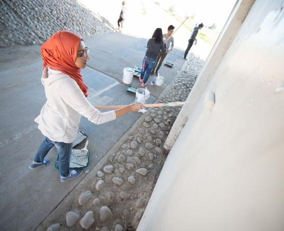 Students painting wall for service day